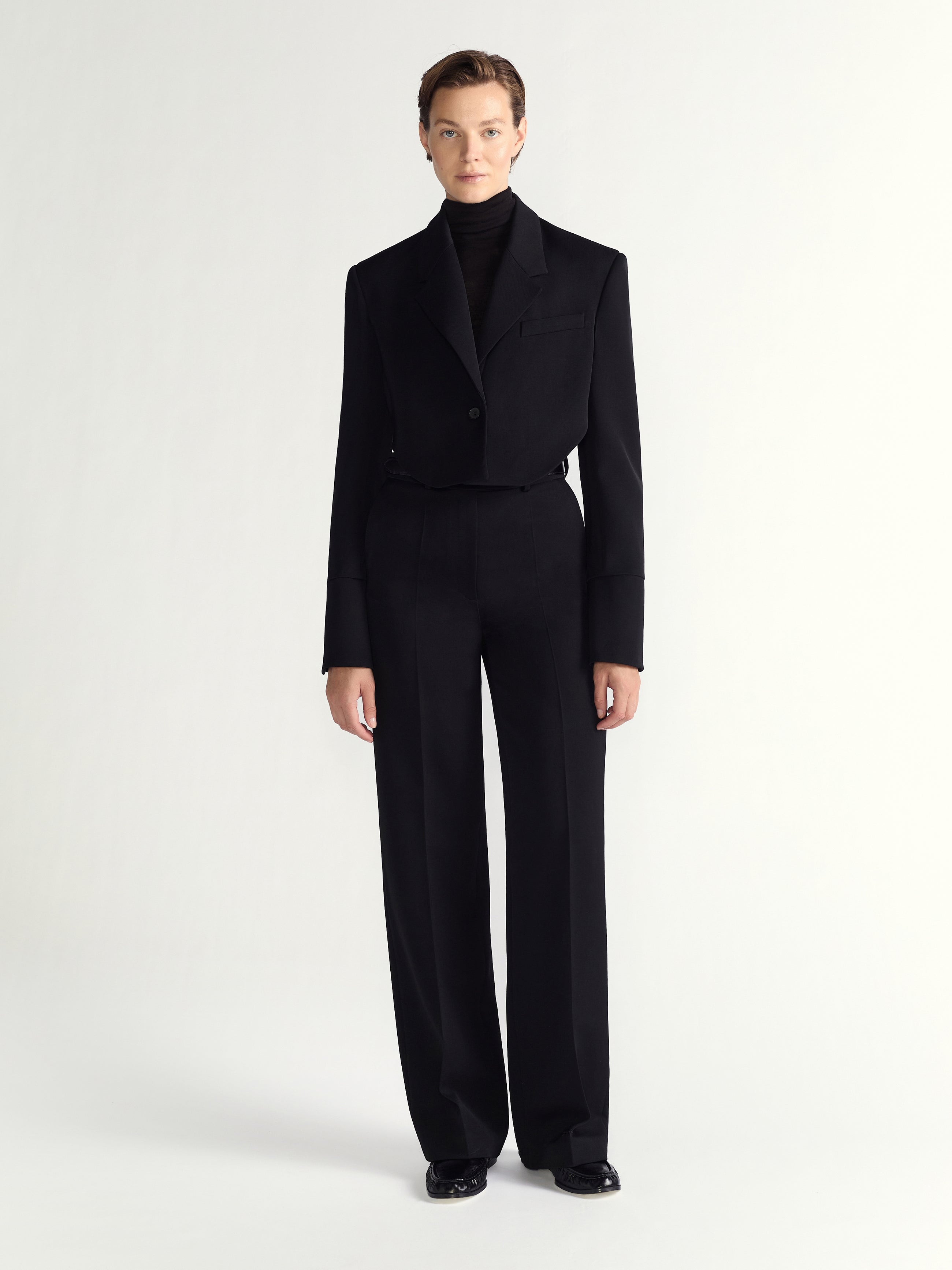 Person wearing black pants on a white background