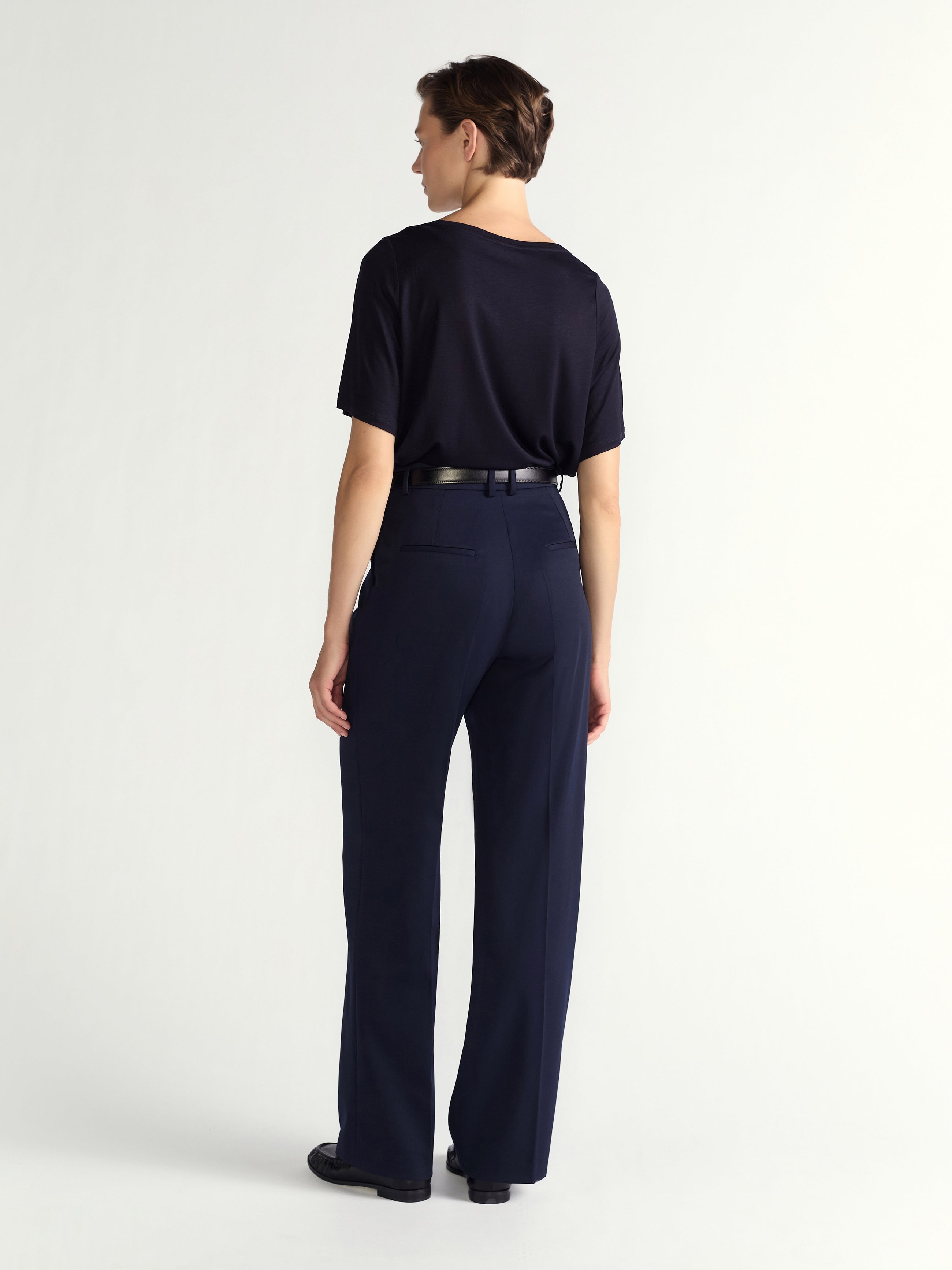 Person wearing a navy outfit on a white background