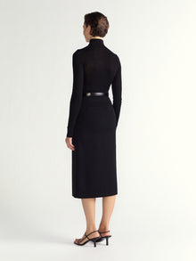 Woman wearing a black dress with a belt on a white background