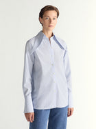 Person wearing a light blue shirt with a white background