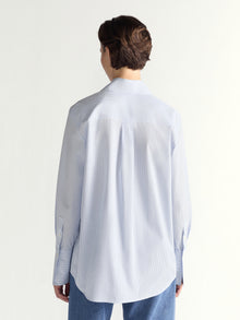 Person wearing a light blue shirt from behind on a white background