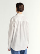 Person wearing a white shirt and blue pants on a white background