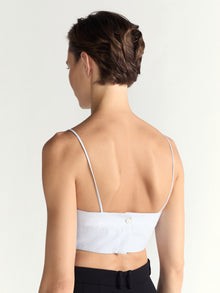 Person wearing a blue top on a plain background