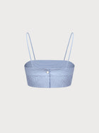 Light blue ribbed crop top with thin straps on a light gray background