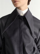 Close-up of a person wearing a dark gray shirt.