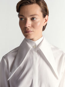 Person wearing a white shirt against a light background
