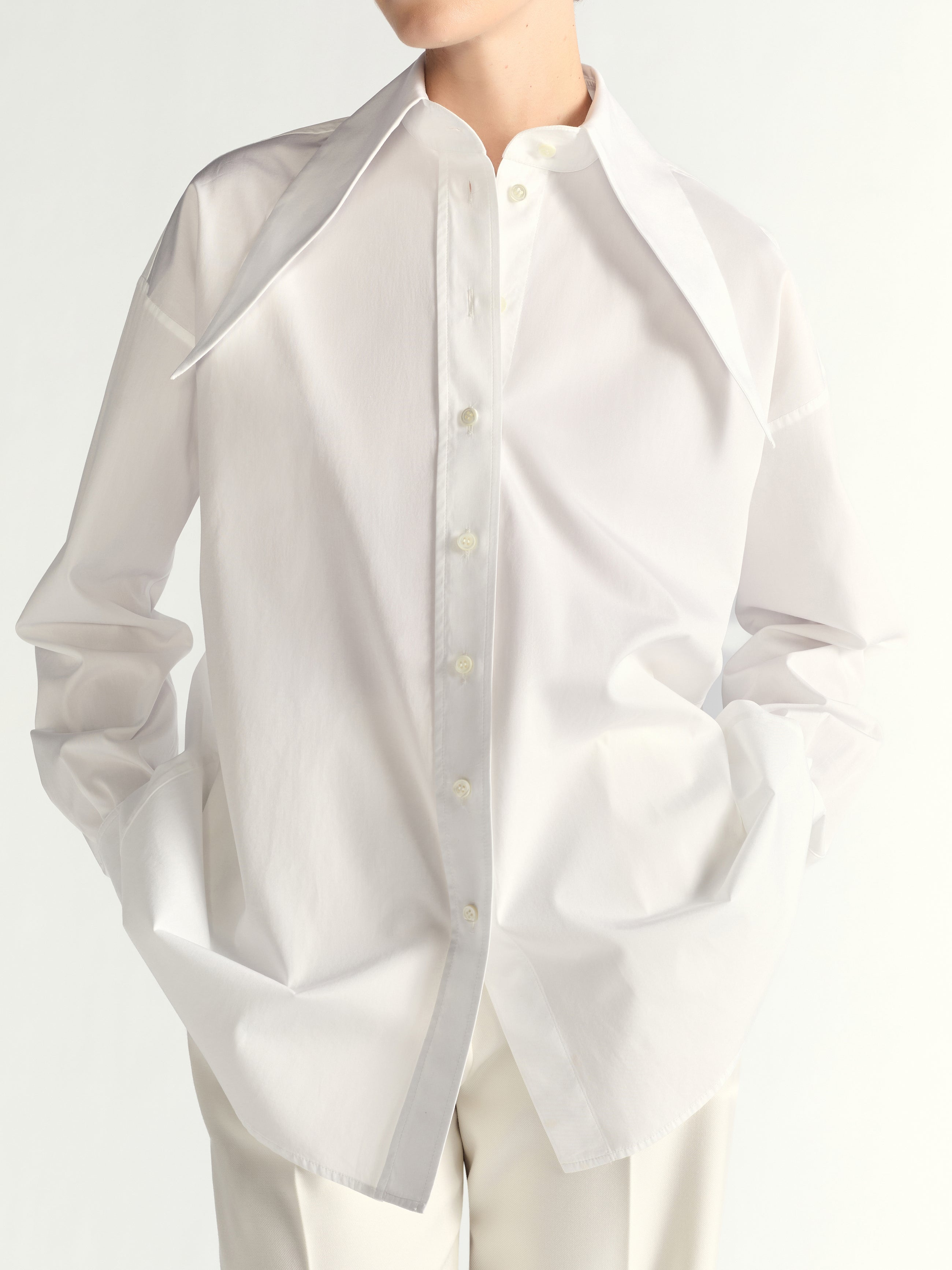 White button-up shirt worn by a person on a white background