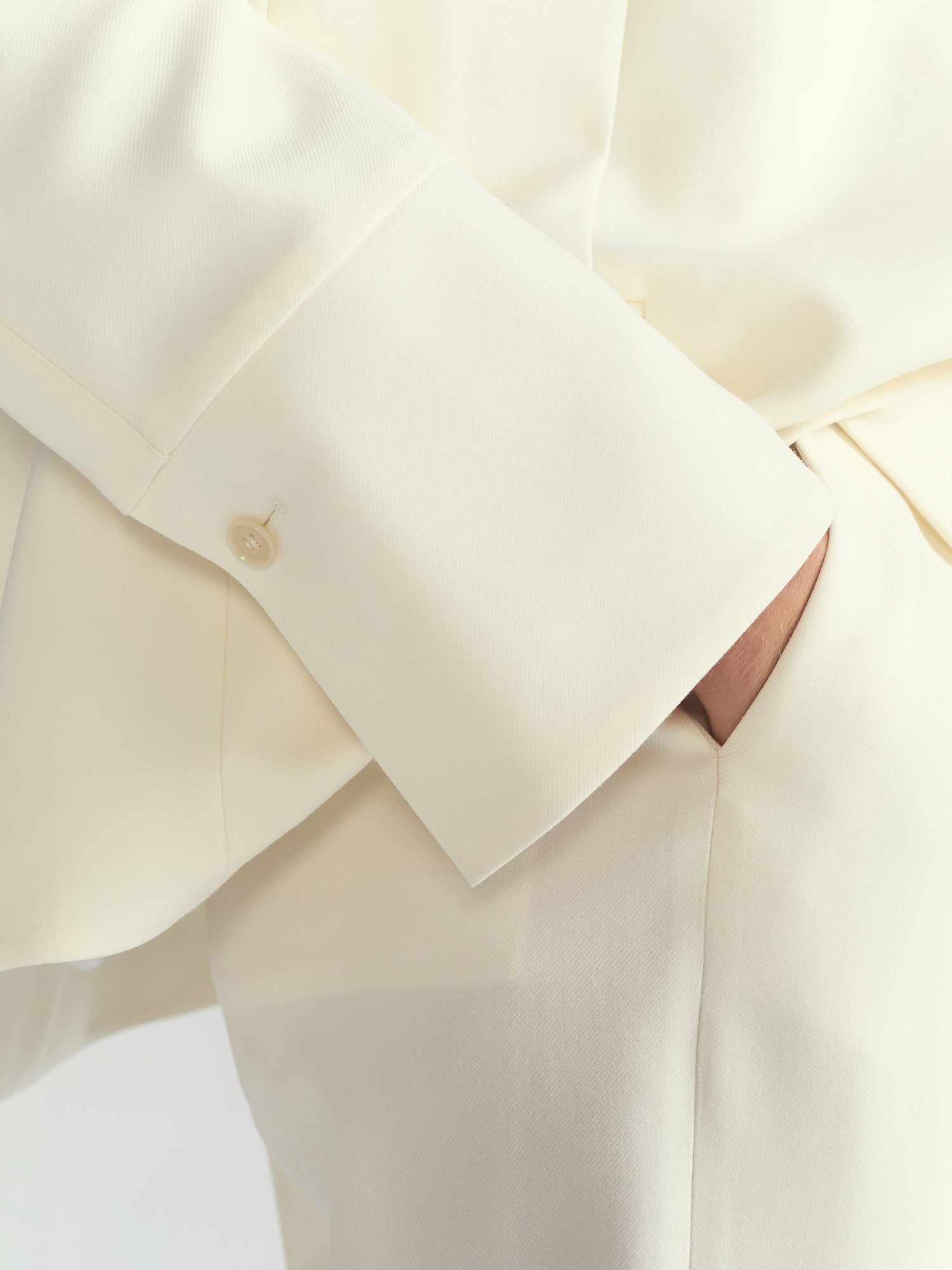 Close-up of a cream-colored garment with a brand logo.