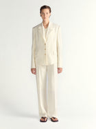 Person wearing an ivory suit on a white background
