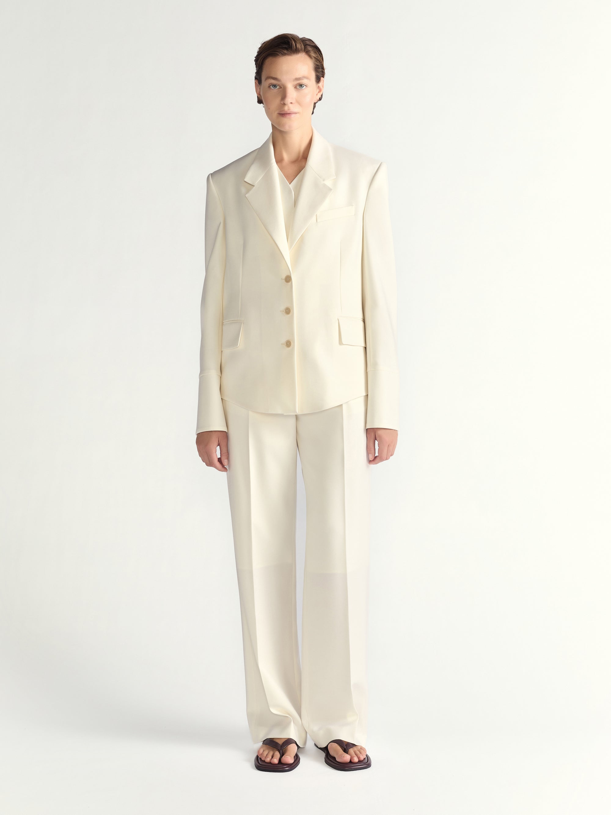 Person wearing an ivory suit on a white background
