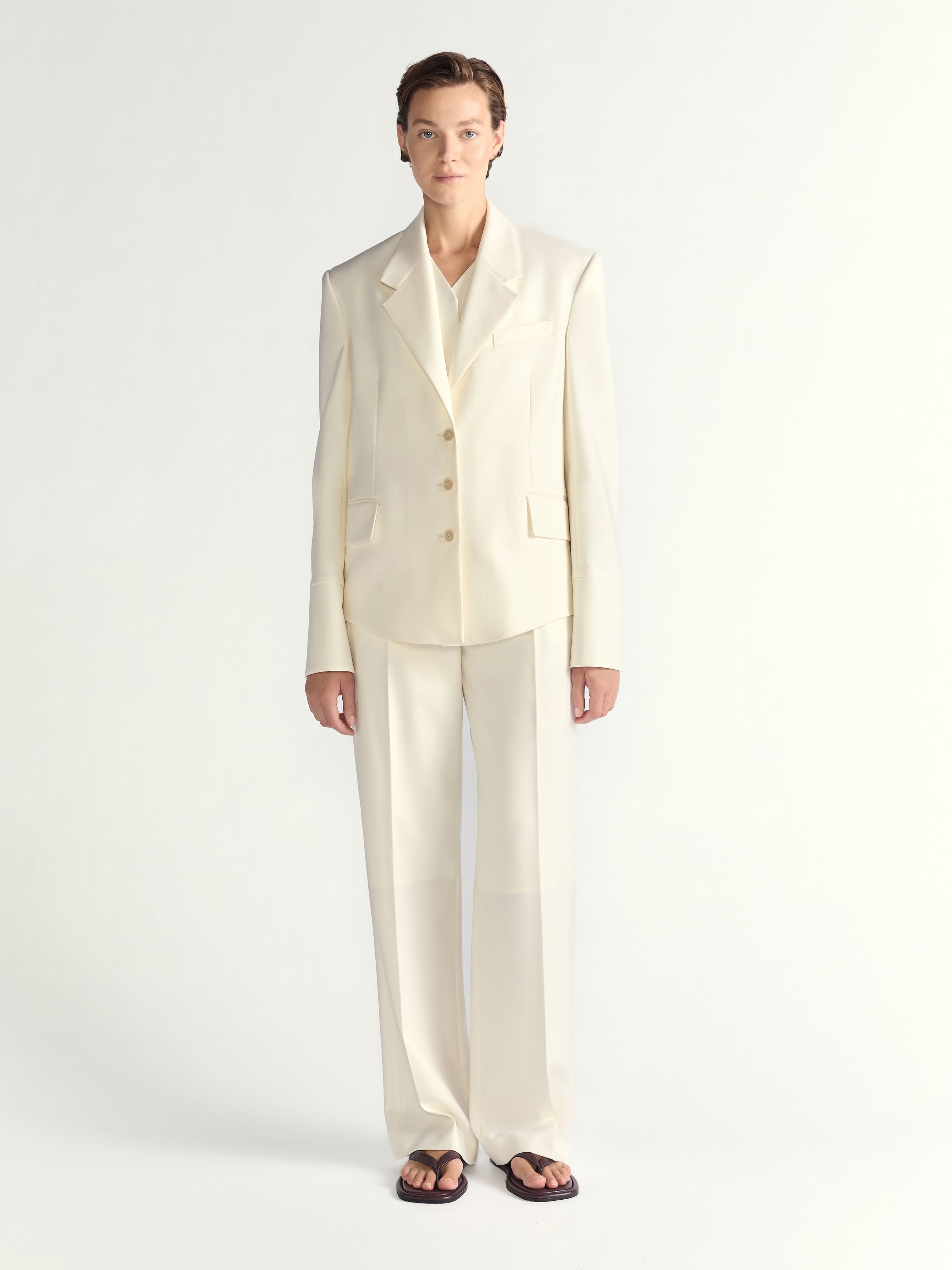 Person wearing an ivory suit on a white background