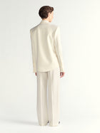 Person wearing a cream-colored suit on a white background