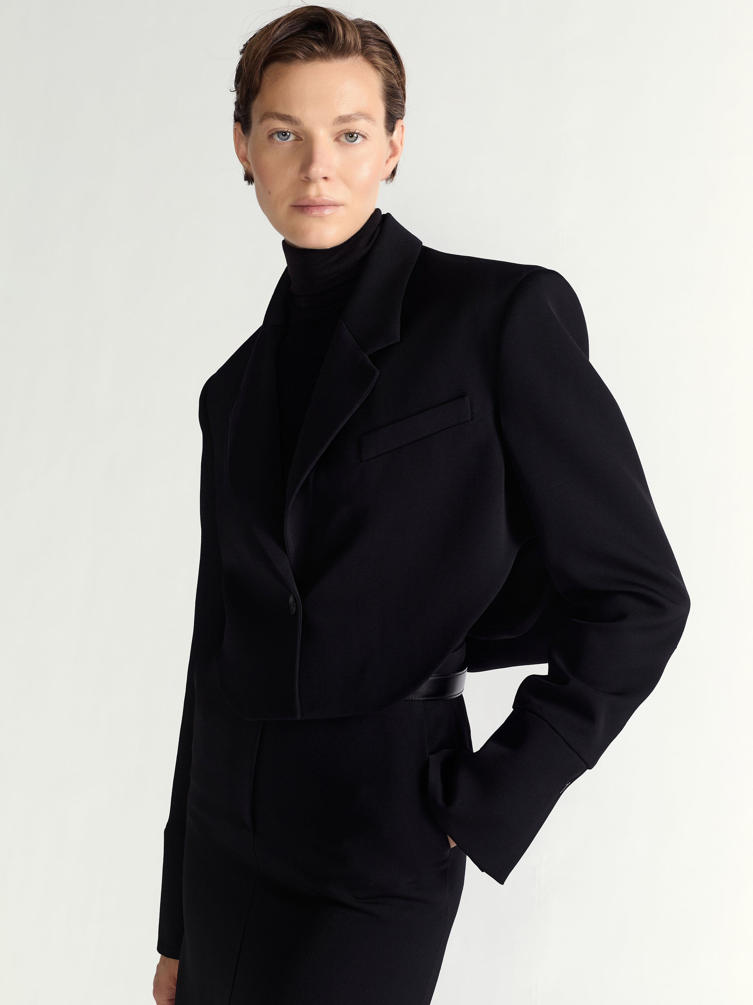 Person wearing a black coat on a white background