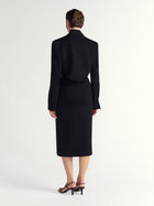 Person wearing a black suit on a white background