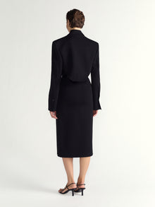 Person wearing a black suit on a white background