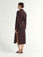 Woman wearing a brown skirt with a slit on a white background