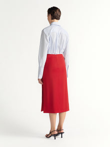 Person wearing a white shirt and red skirt on a white background