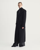 Person wearing a long grey coat on a white background