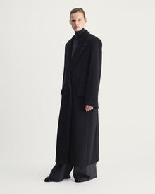 Person wearing a long grey coat on a white background