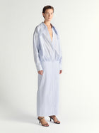 Woman wearing a light blue long-sleeve dress on a white background