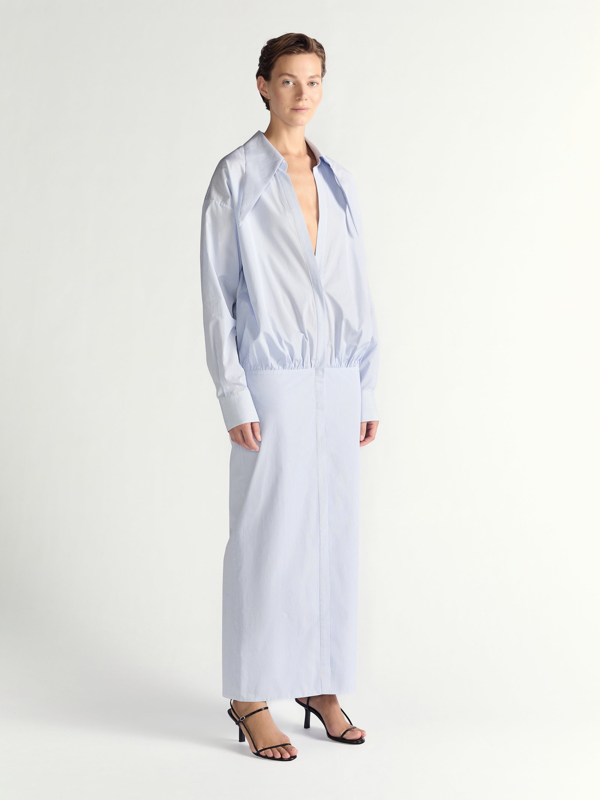 Woman wearing a light blue long-sleeve dress on a white background