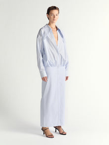 Woman wearing a light blue long-sleeve dress on a white background