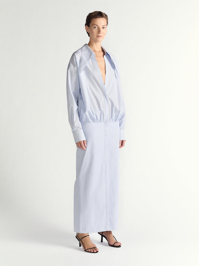 Woman wearing a light blue long-sleeve dress on a white background