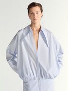 Person wearing a light blue dress against a white background