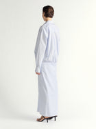 Person wearing a light blue stripe ddress on a white background