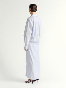 Person wearing a light blue stripe ddress on a white background