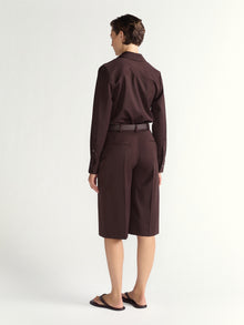 Person wearing a brown shirt and matching shorts on a white background