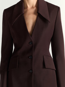 Brown blazer with buttons on a plain background
