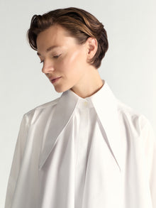 Person wearing a white shirt against a light background