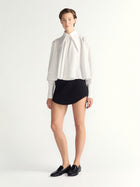 Person wearing a white blouse and black skirt on a white background