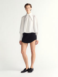 Person wearing a white blouse and black skirt on a white background
