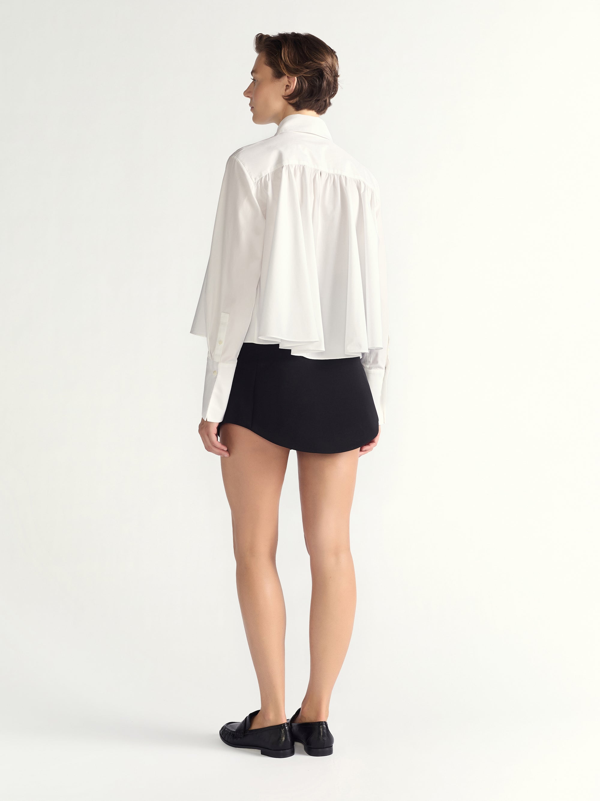 Person wearing a white blouse and black skirt on a white background