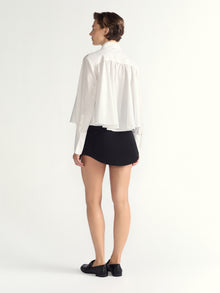 Person wearing a white blouse and black skirt on a white background