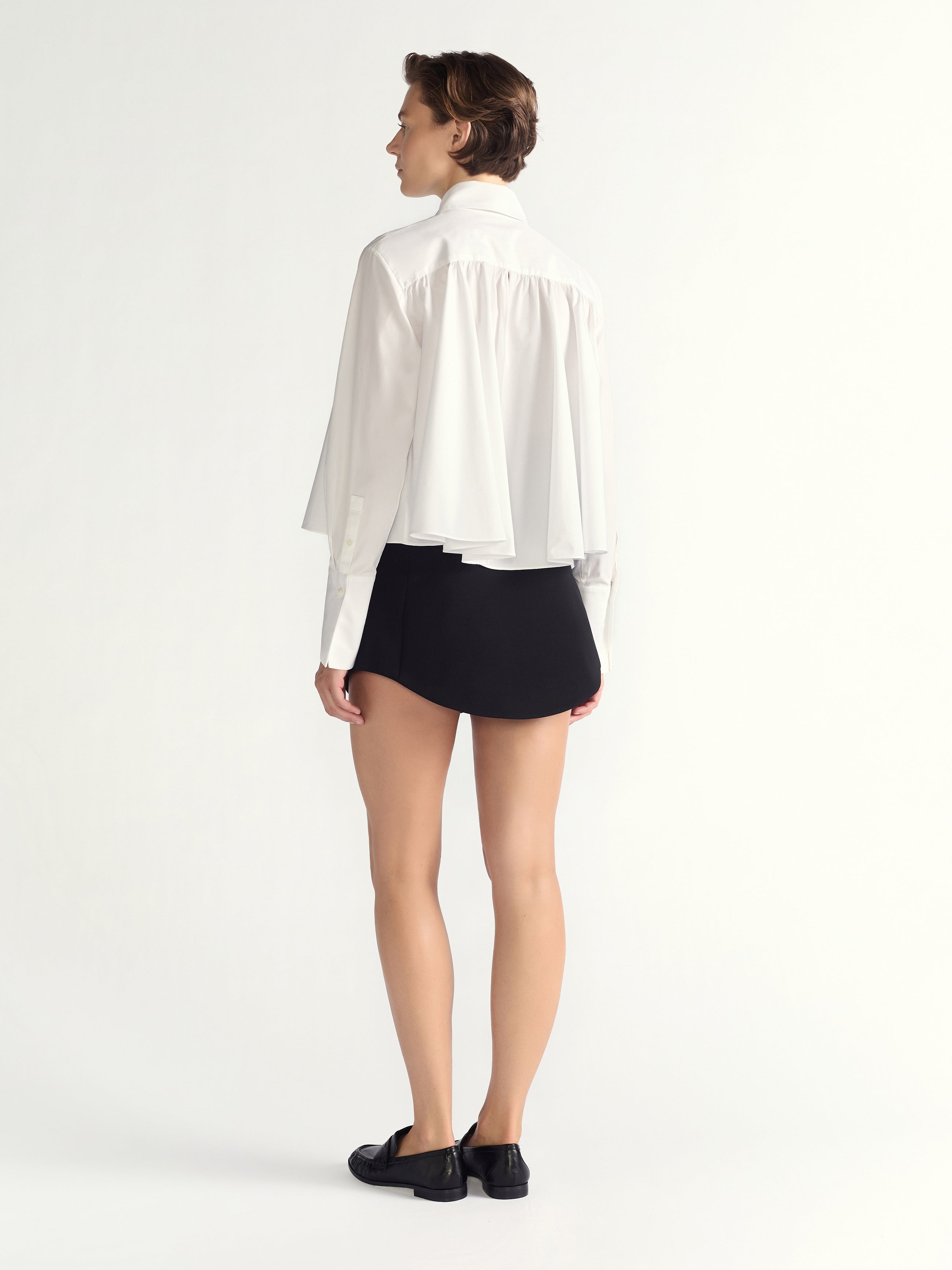 Person wearing a white blouse and black skirt on a white background