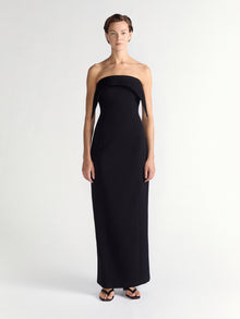 Woman wearing a black strapless gown on a white background