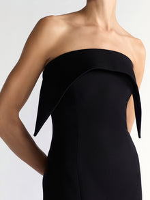 Black strapless dress on a plain background