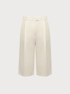 White wide-leg pants on a light beige background