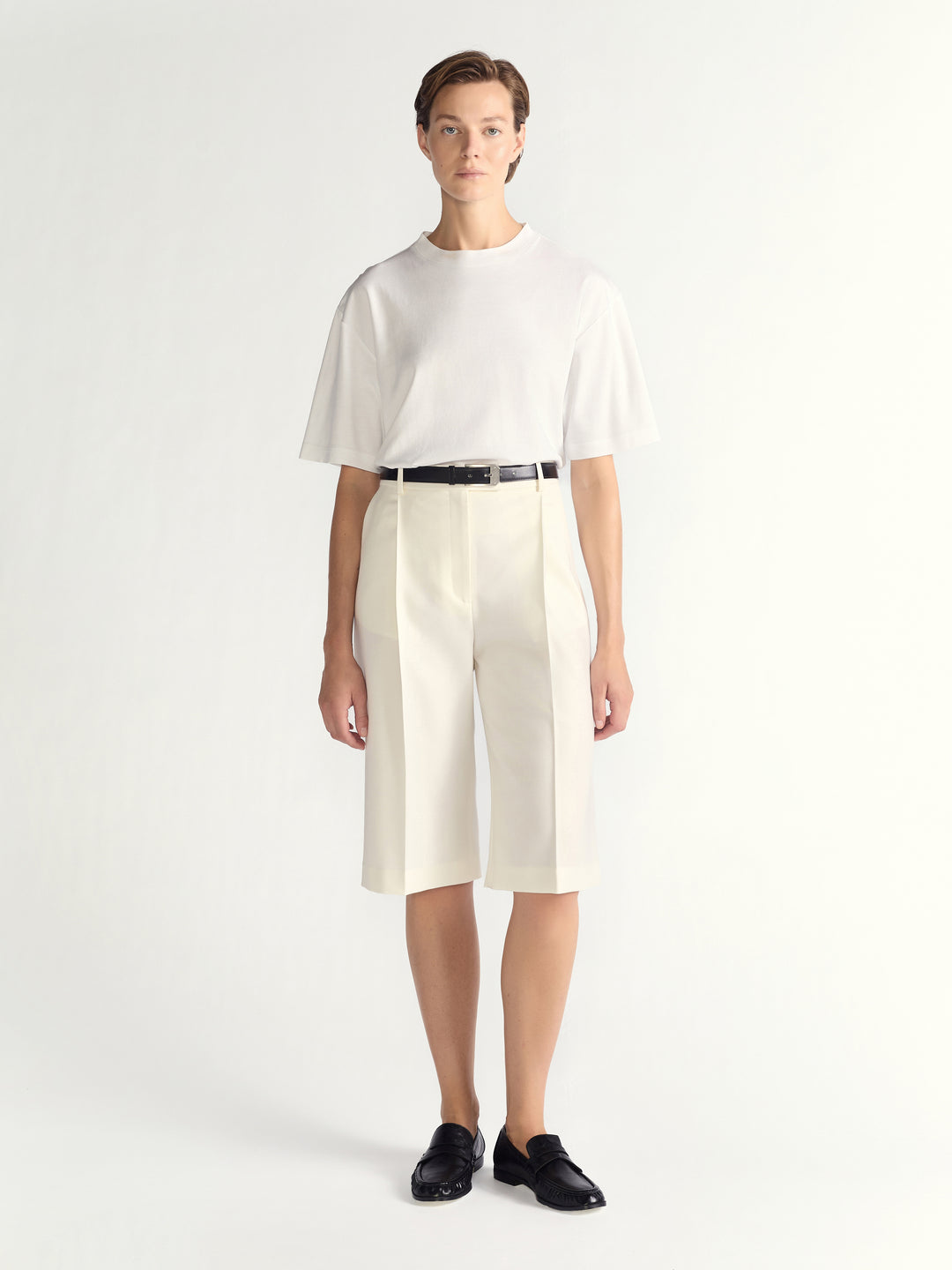 Person wearing a white outfit with a black belt on a white background