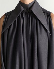 Black sleeveless dress with a large collar on a neutral background
